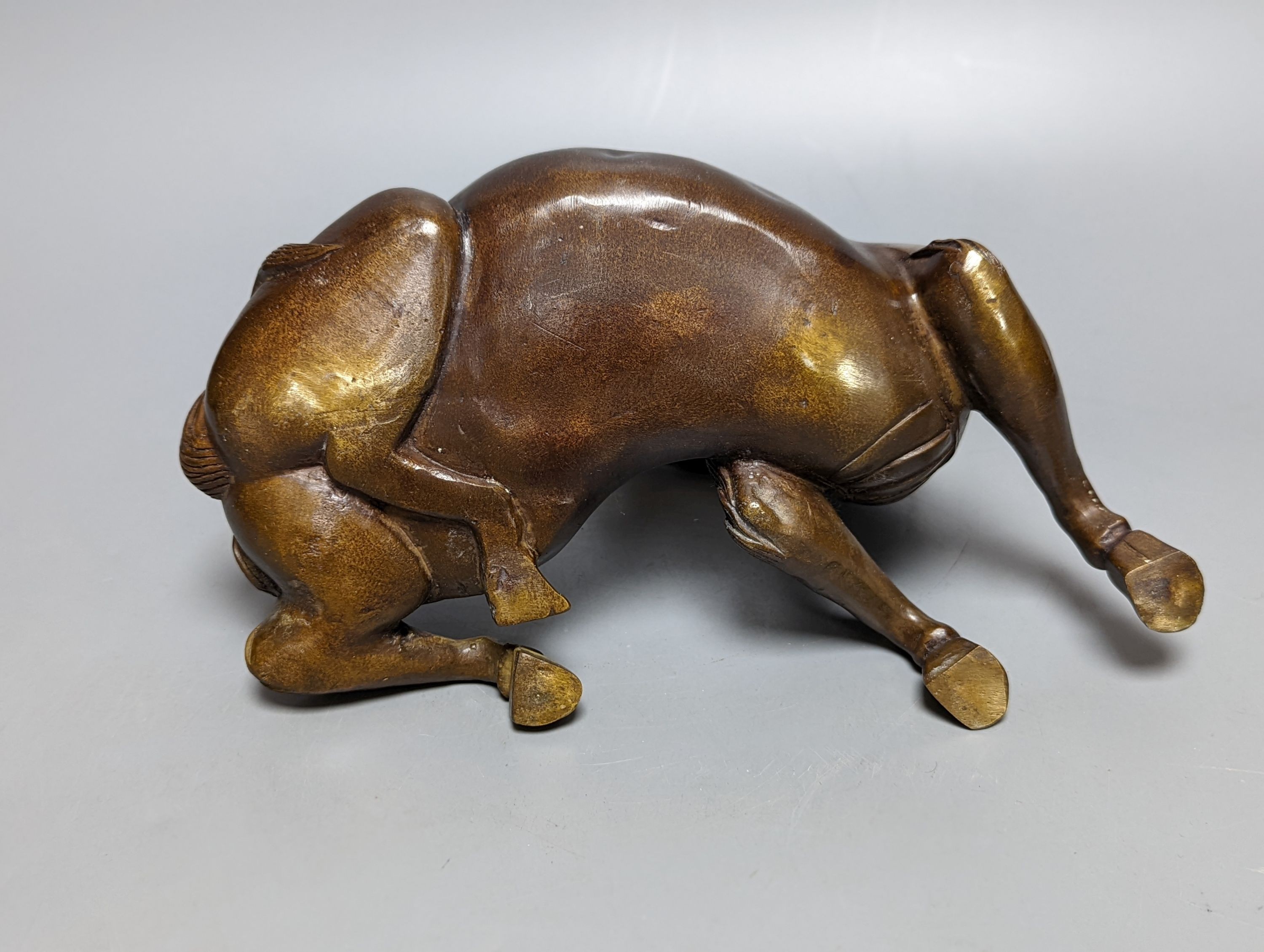 A Chinese parcel-gilt bronze incense burner and cover, modelled as a recumbent qilin, Qing dynasty, 19th century, 25 cms wide.